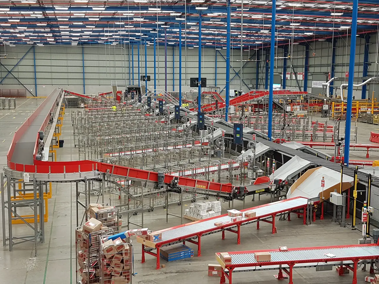 A wide warehouse layout with elevated conveyors, diverters and extensive sorting lanes.